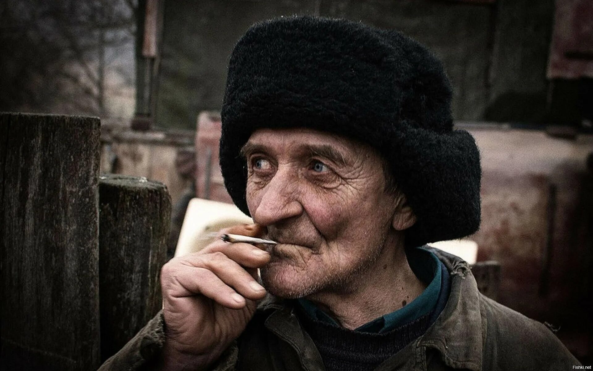 Старик строго. Старик. деревенский мужик в ушанке. дед с сигаретой. старый дедушка.