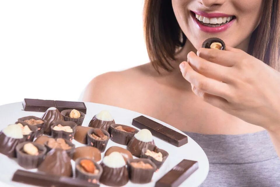 Ночью ем шоколад. Женщина ест шоколадные конфеты. Девушка с шоколадной конфетой. Девушка ест конфету. Женщина с конфетами.