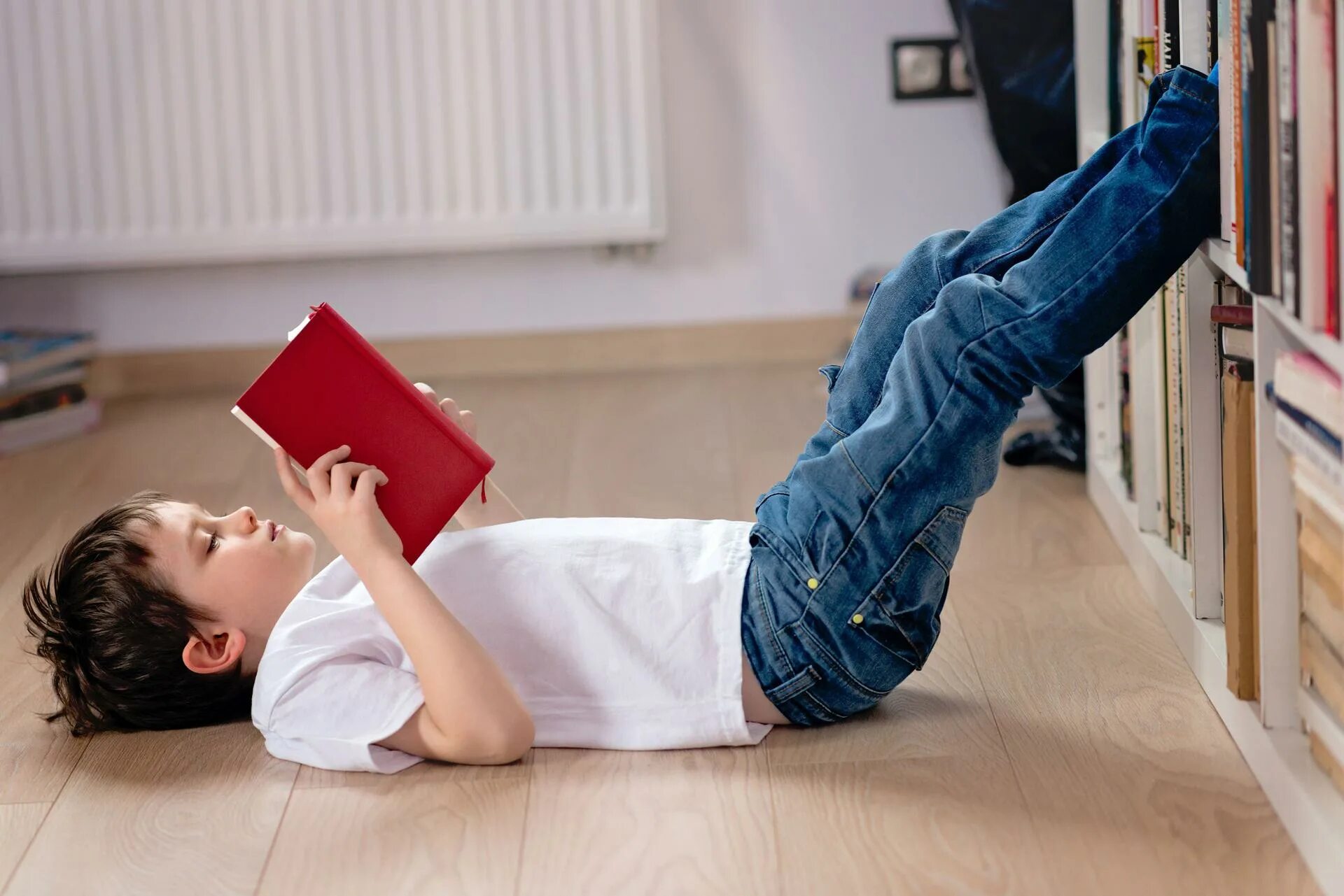 Неверный читать. Чтение лежа. Мальчик лежит. Ребенок читает лежа. Школьник лежит на полу.