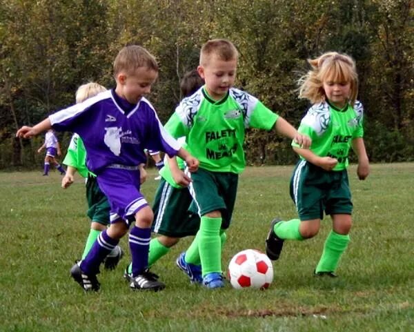 Детский футбол во дворе. Фотосессия на футбольном поле ребенка. Дети играющие в мяч. Дети играют в мяч. Дети не детской площадке.