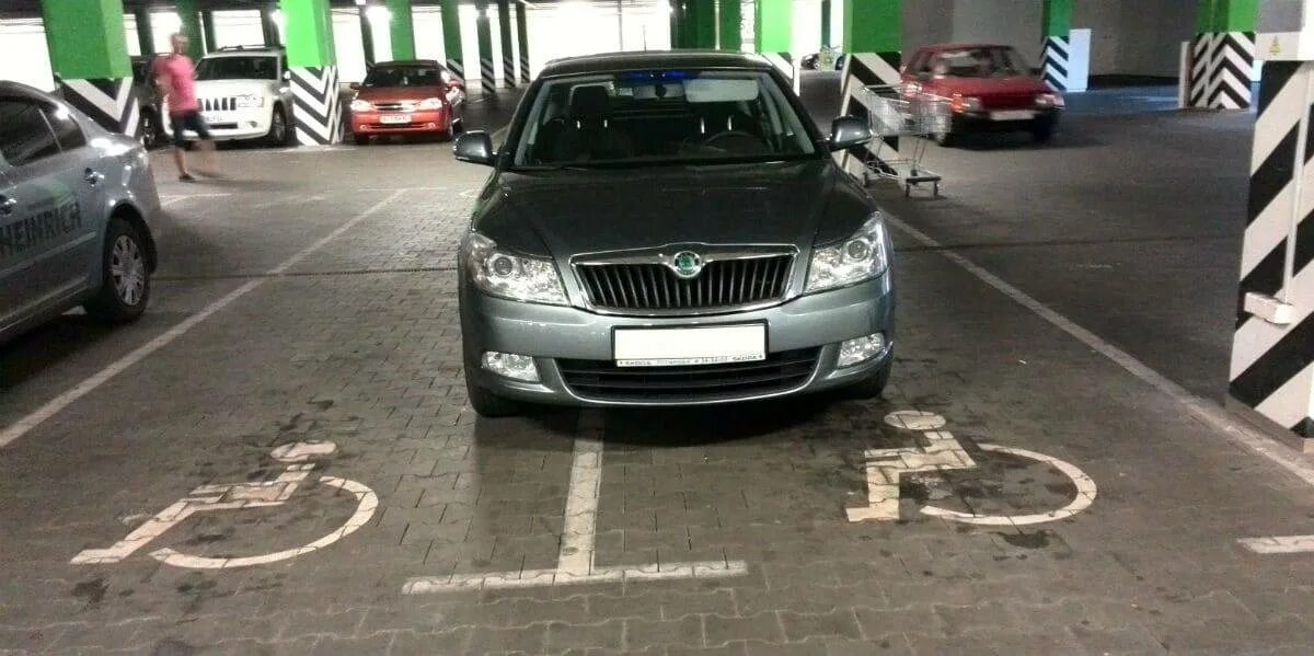 Парковка для автомобилей инвалидов. Стоянка для инвалидов. Машина стоит на инвалидном месте. Машина стоит на инвалидном месте. Парковочное место для инвалидов.