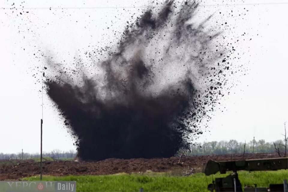 Слышны разрывы снарядов. Воронка от взрыва. Подрыв боеприпасов на полигоне.