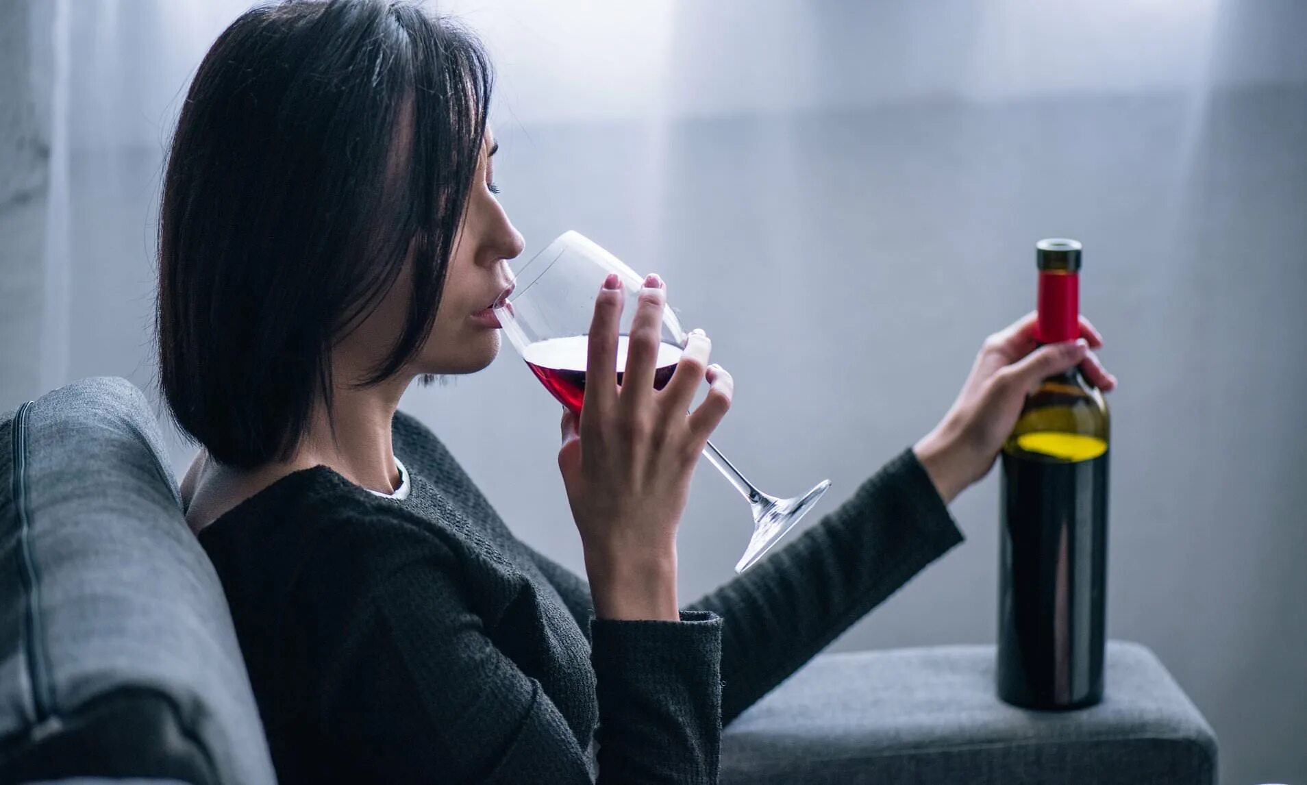 Женщина пьет. Пьющая девушка. Одинокая женщина пьет. Девушка пьет вино. В ее руках вино