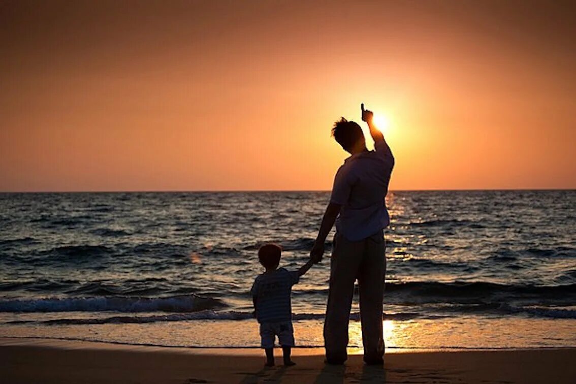 Отец и сын. Ребенок на спине у папы. Папа с ребенком на закате. Папа сын на берегу моря.