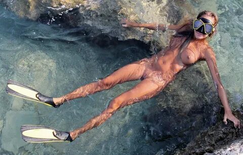 Голые женщины с ластами под водой.