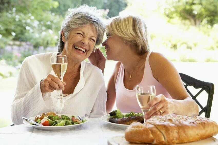 Пожилые подруги. Две женщины в возрасте беседа. Немолодые подруги с бокалами. Две пожилые дамы в летнем кафе.