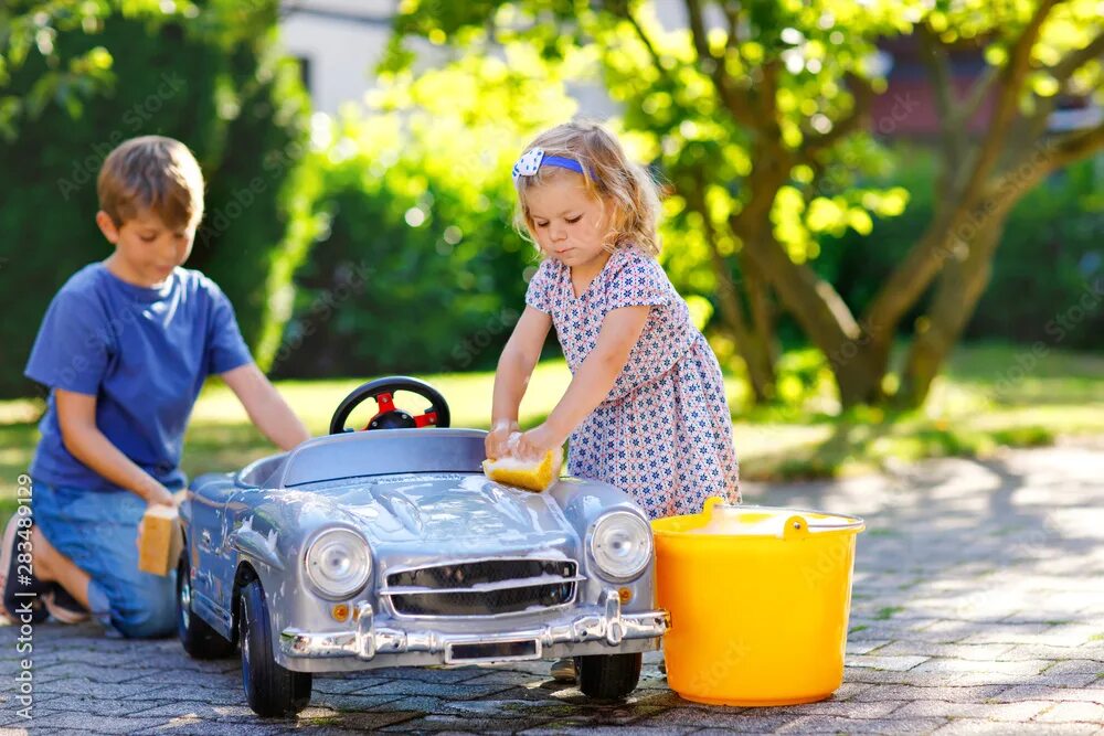 The children have washed. Моет машину в природе для детей. Kids washing car. Family washing car and smiling.