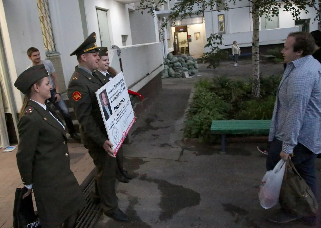 Вручение повесток призывникам. Вручение повестки в военкомат. военком вручает повестку. работники военкомата.