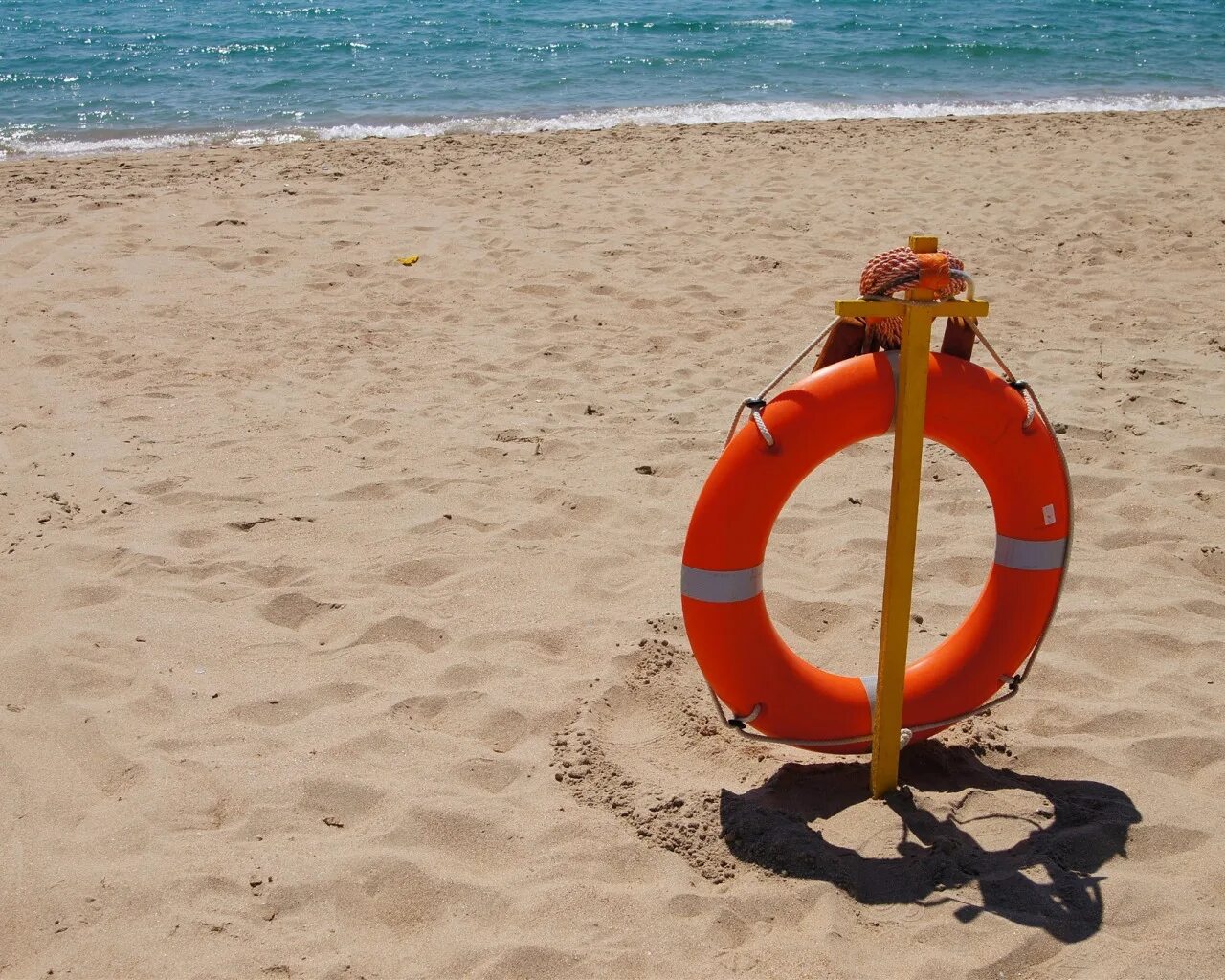 Спасательный круг в море. Спасательный круг на пляже. Спасательный круг ю на пляже. Спасатель на море. Спасатель на пляже.