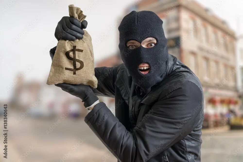 A thief steals. Братаны толпа в балаклавах. Бандит с мешком денег. Человек бандит. Ограбление на улице.