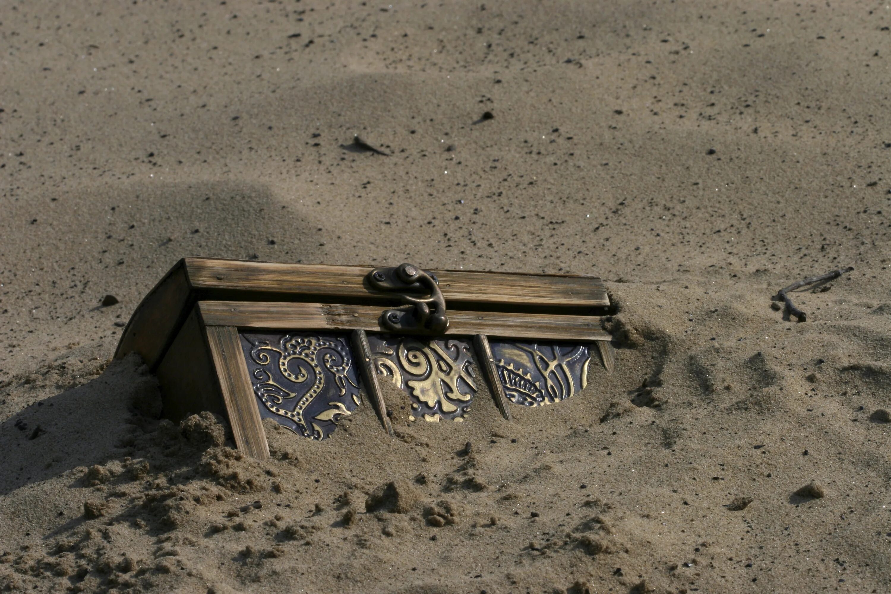 Где зарыт клад пиратов. Сундук с сокровищами на песке. Сундук в песке. Сундук в земле. Сокровища в песке.