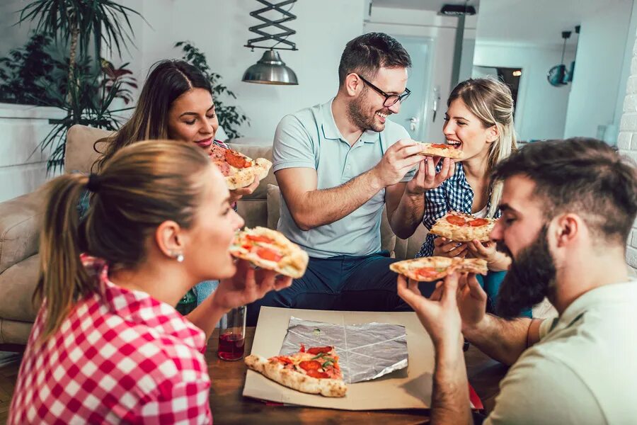 Бывать друг у друга дома. Ест пиццу. Семья в пиццерии. Пицца в компании друзей. Семья ест пиццу.