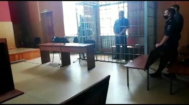Заключенный в зале суда. Фото из зала суда. Стол подсудимого.