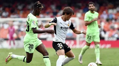 (L) vies with Valencia's Spanish defender Jesus Vazquez during the Spa...