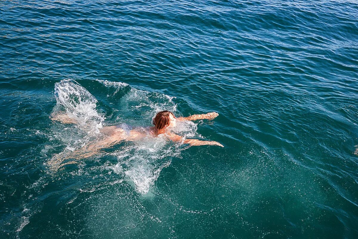 Купание м. Плавать в море. Плывет в море. Люди купаются в море. Девушка плывет в море.