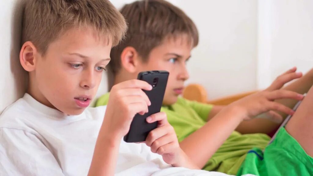 My brother plays computer games. Мальчик играет в телефон. Два мальчика играют в телефоны. Мальчик играет в телефон с лица.