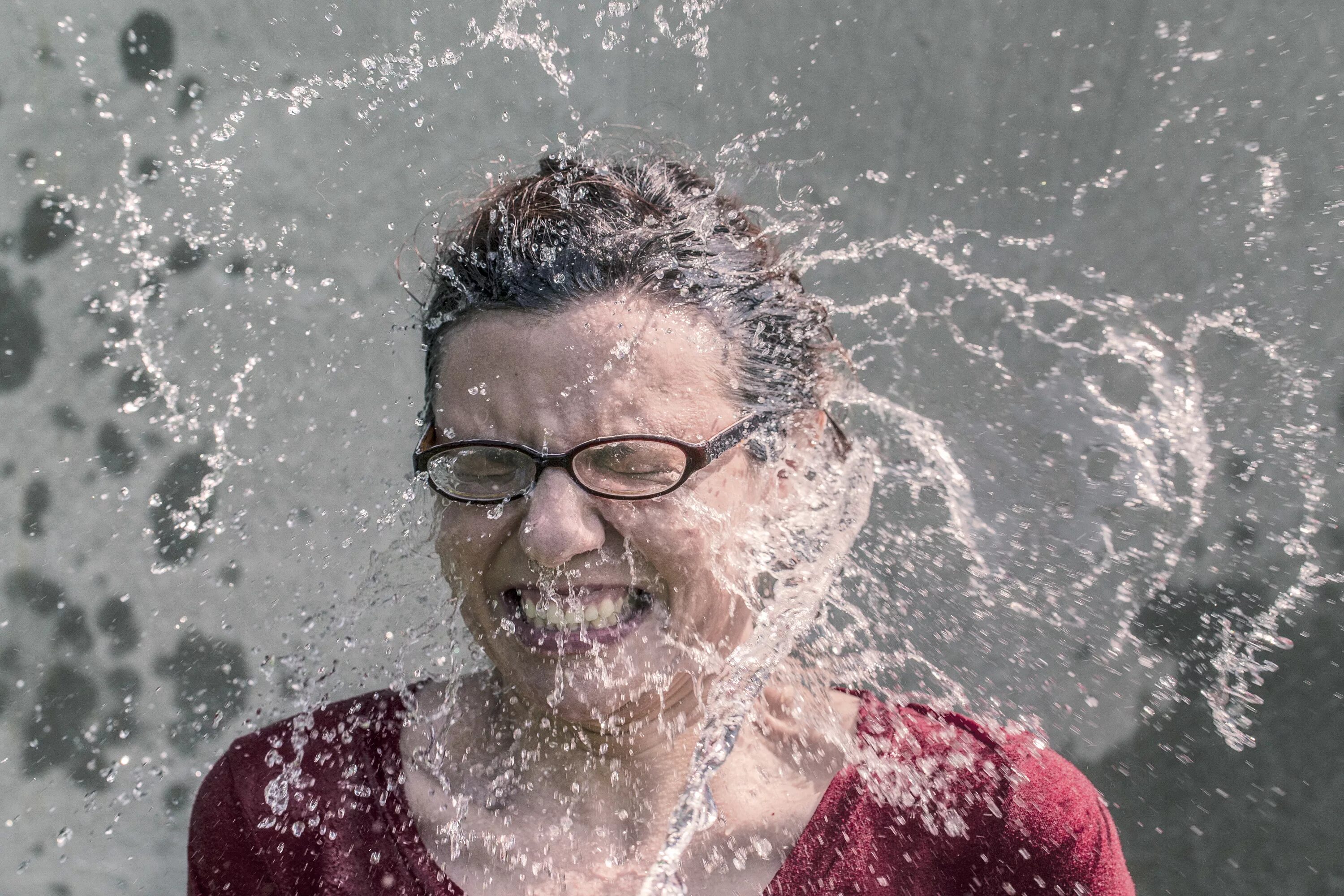 Лицо в воде. Обрызгали водой человека. Брызги воды на лице. Мокрый человек.