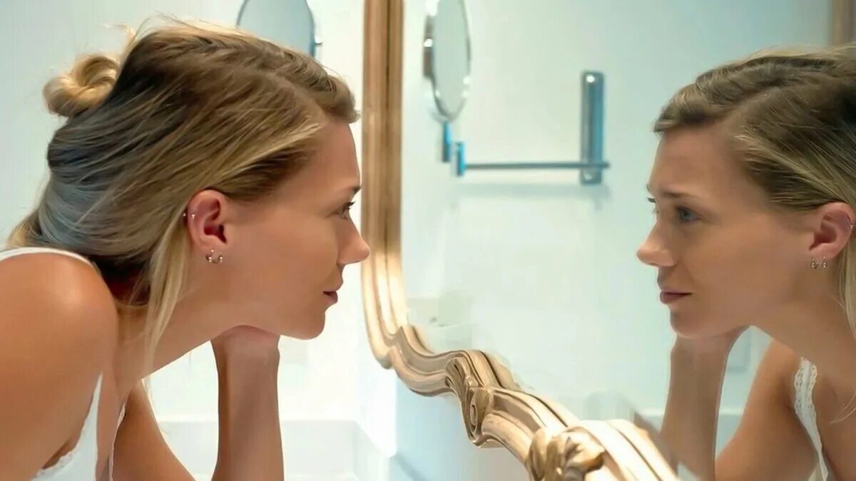 Смотреться в зеркало. Девушка смотрит в зеркало. Женщина любуется в зеркало. Женщина смотрится в зеркало.