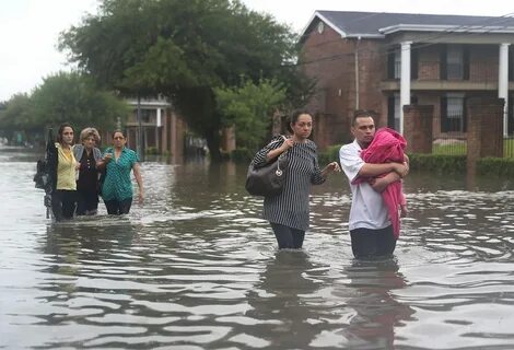 ...as they evacuate their homes after the area was inundated with flooding ...