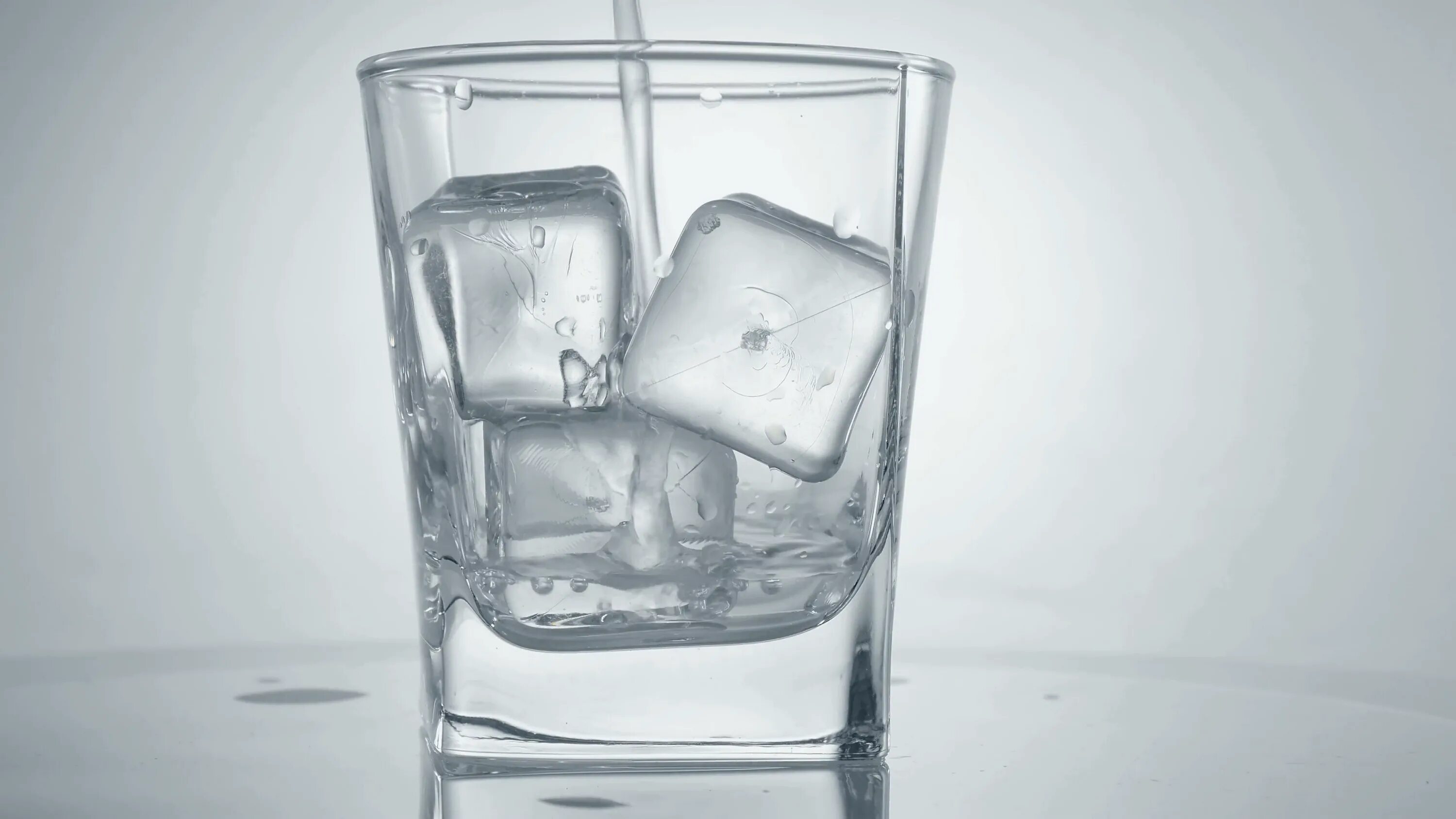 Лед в стакане. Стаканы Ice. Ice Cubes in a Glass. Прозрачный коктейль с большим кубом льда.