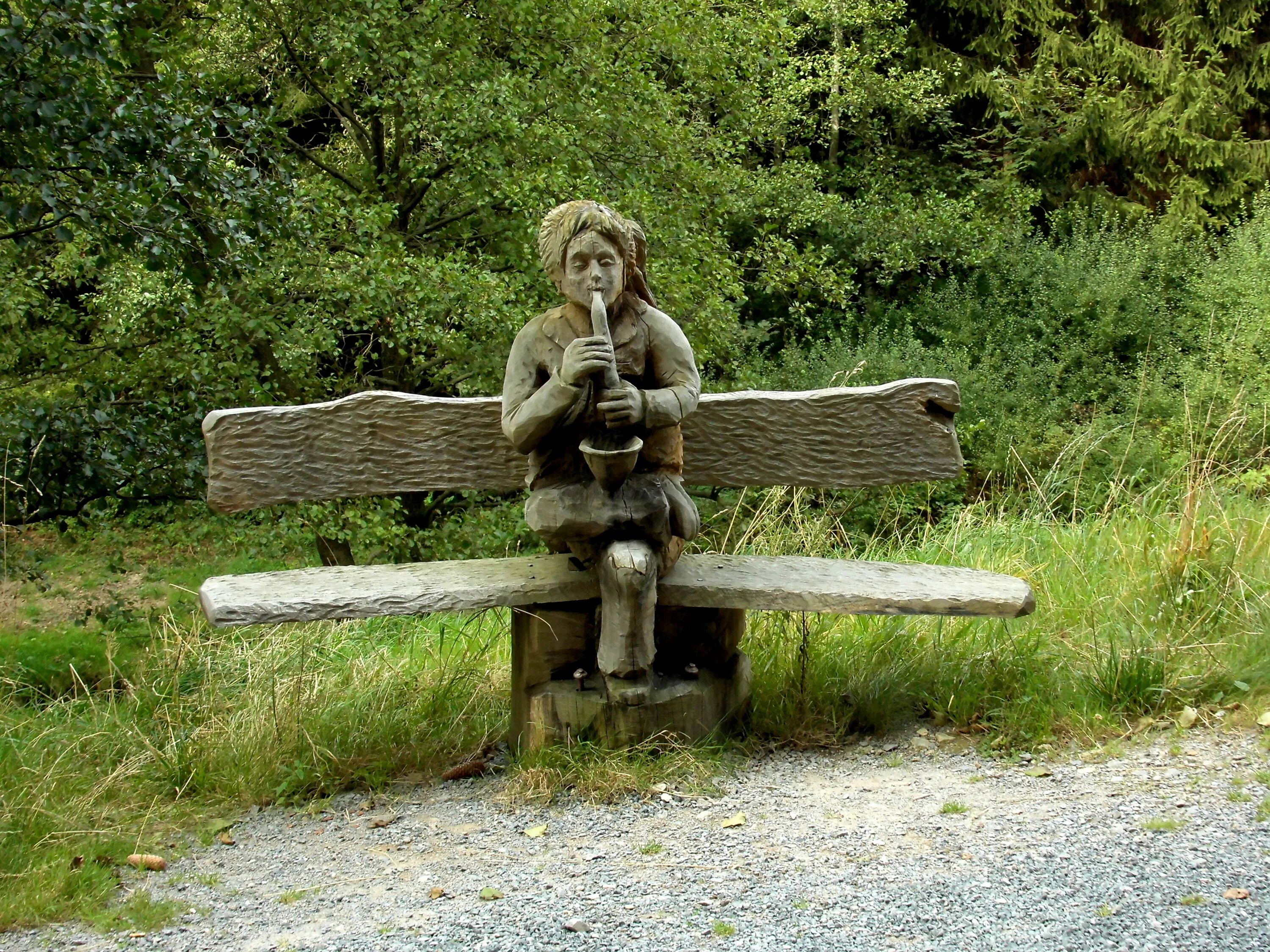 Ни сидит на месте. Скульптура на скамейке. Необычные скамейки. Деревянные скамейки с фигурами. Скульптура деревянных скамеек.