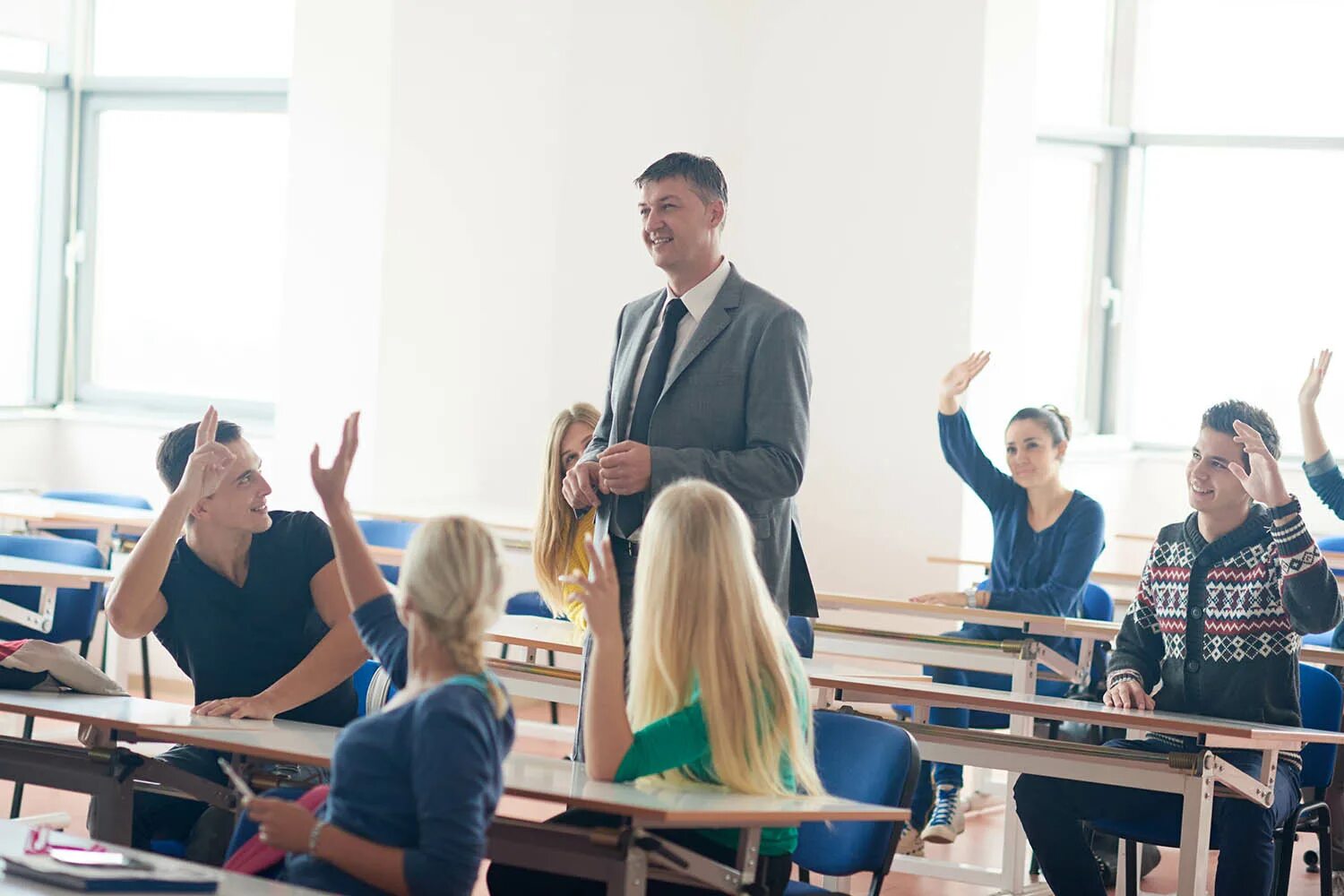 Общение преподавателя со студентами. Студенты здороваются с преподавателем. студенты приветствуют преподавателя. учитель здоровается со студентами. группа учителей.