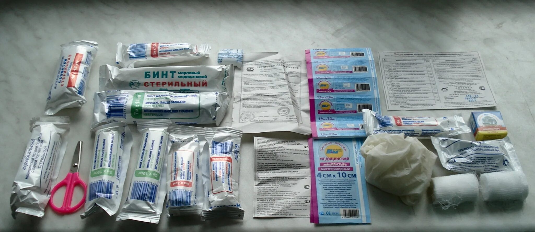 Комплект для оказания первой помощи. Аптечка доврачебной помощи. Набор лекарств в аптечке. Жгут в автомобильной аптечке. Таблетки в автомобильной аптечке.