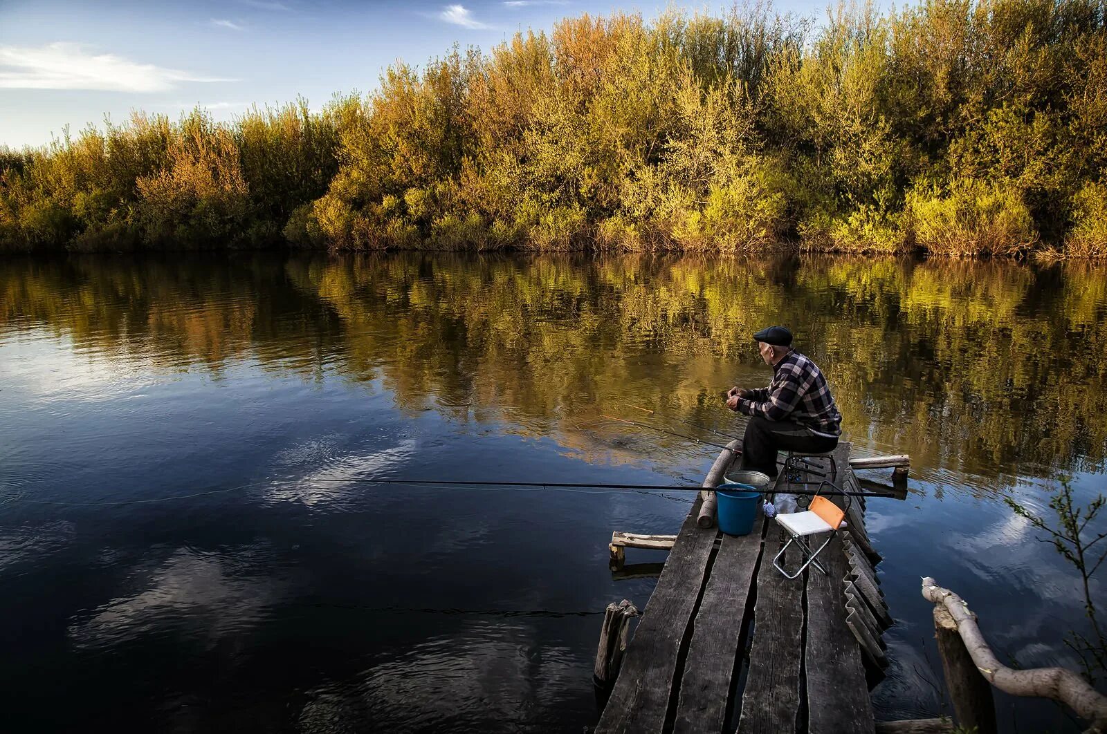 Рыбак на реке. Природа на охоте и рыбалке. Рыбак на берегу реки.