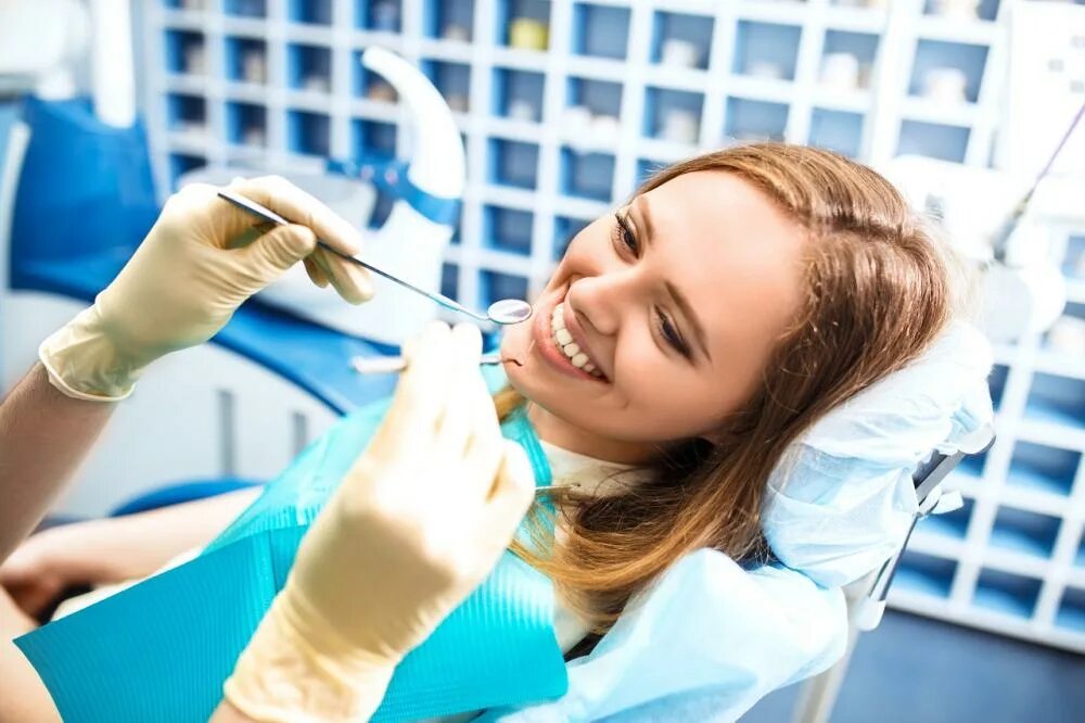 Врач лечащий кариес. Стоматолог. Красивая девушка стоматолог. Профессиональная гигиена полости рта.