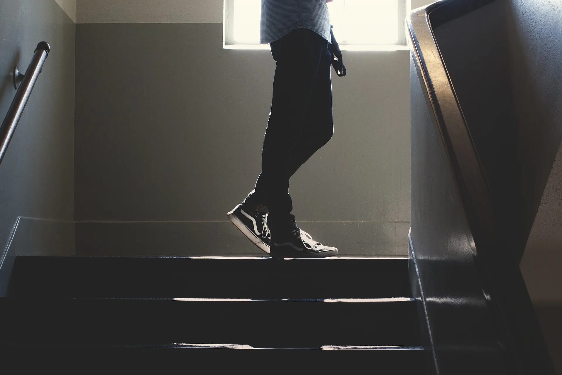 Подниматься по лестнице. Поднимается по лестнице. Парень спускается по лестнице. Человек на лестнице. Человек на ступеньках.