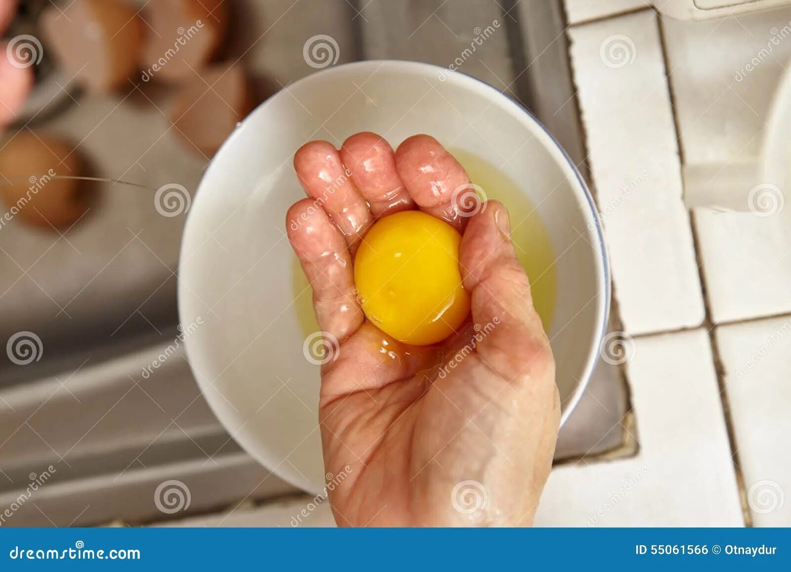 Сырое яйцо. Яйцо в руке. Яичный желток. Разбитое яйцо.