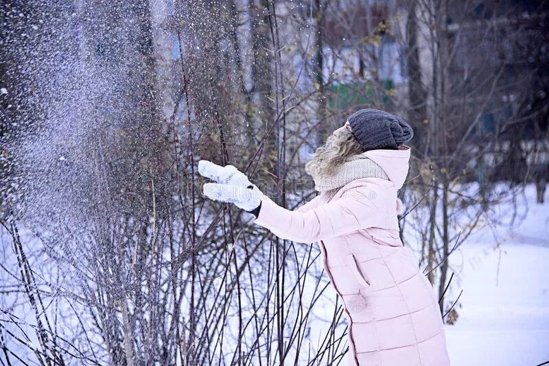 В окно кидают снежки. Девушка бросает снежки. Девушка бросает снежок. Бросать снег. Девочка кидает снег.