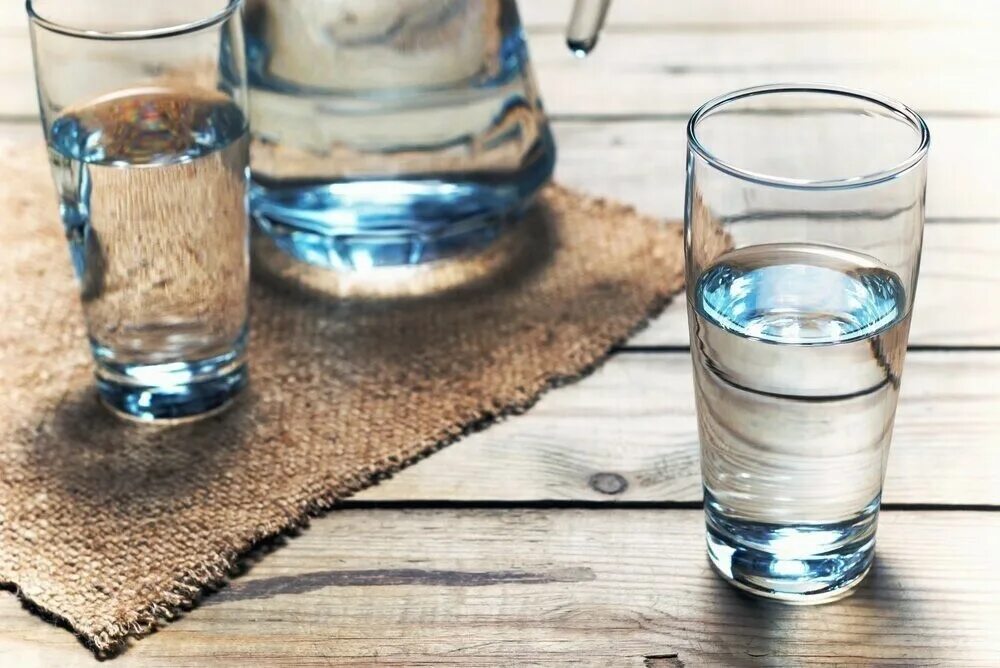 Четыре стакана воды. Стакан воды. Простая вода. Стакан воды на столе. Вода питьевая в стакане.