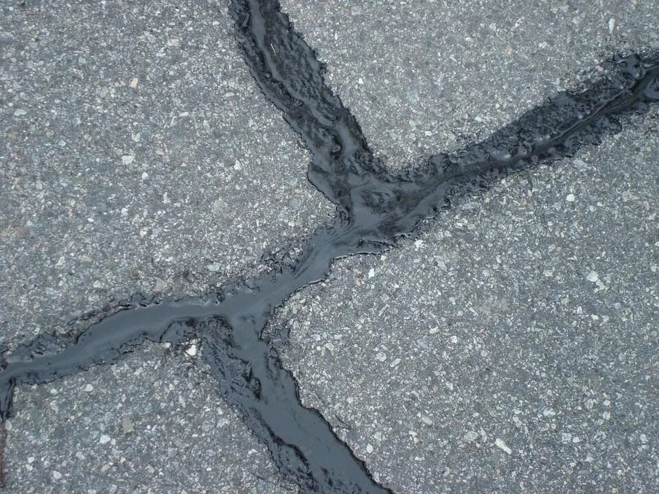 Мокнущий асфальт. Герметизации трещин в асфальтобетонном. стык бетона и асфальта. стык бетонных плит и асфальта. стык асфальта.