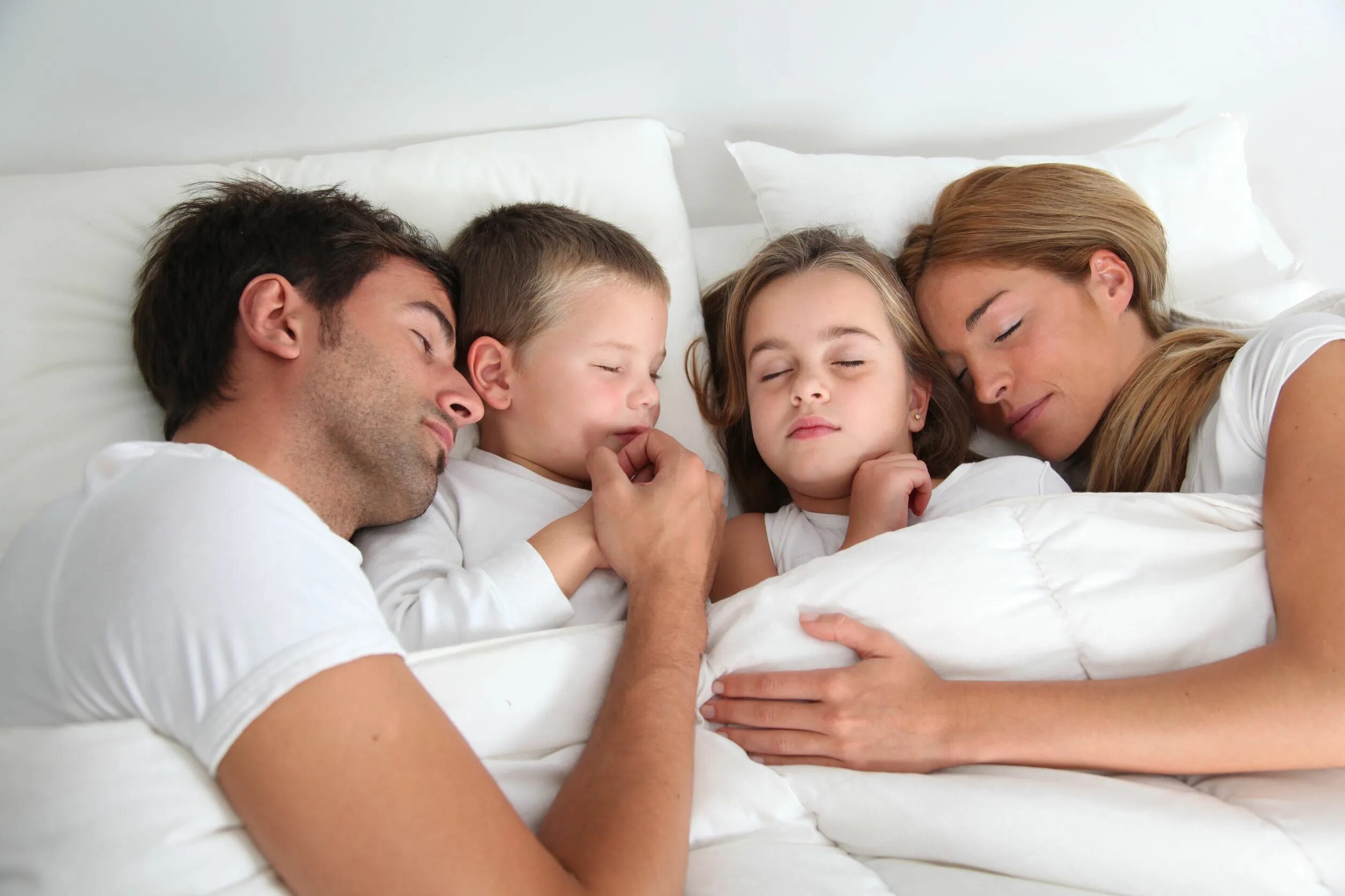 Навестить семью. Ребенок в постели с родителями. Семья на кровати.
