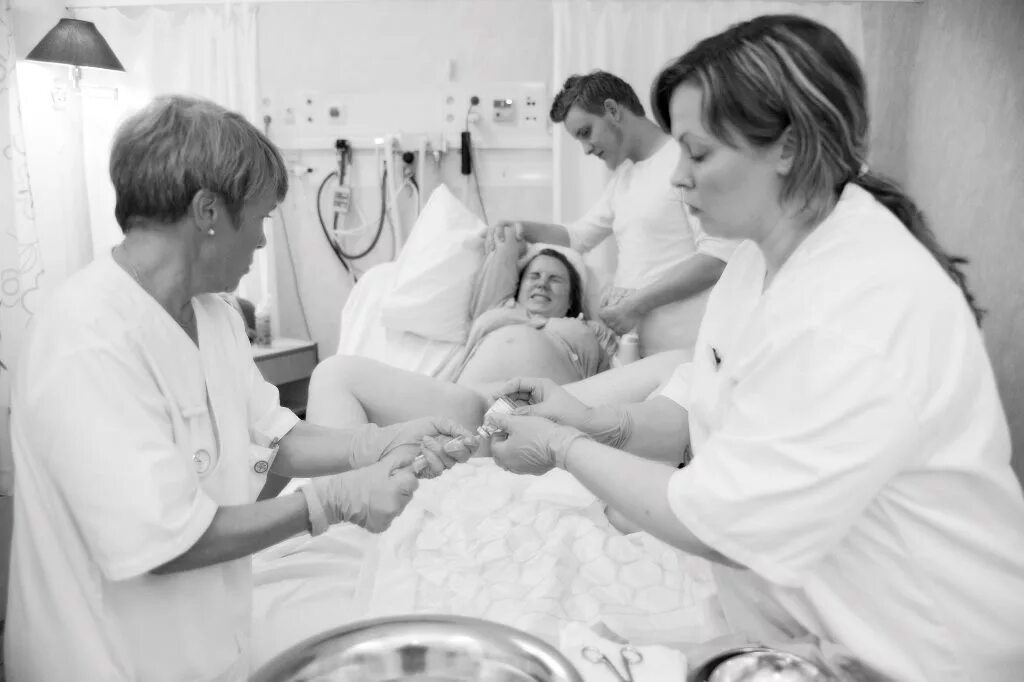 Роды без анестезии. Женщина на родильном столе. Женщина в родильном зале. Процесс рождения ребенка в роддоме.