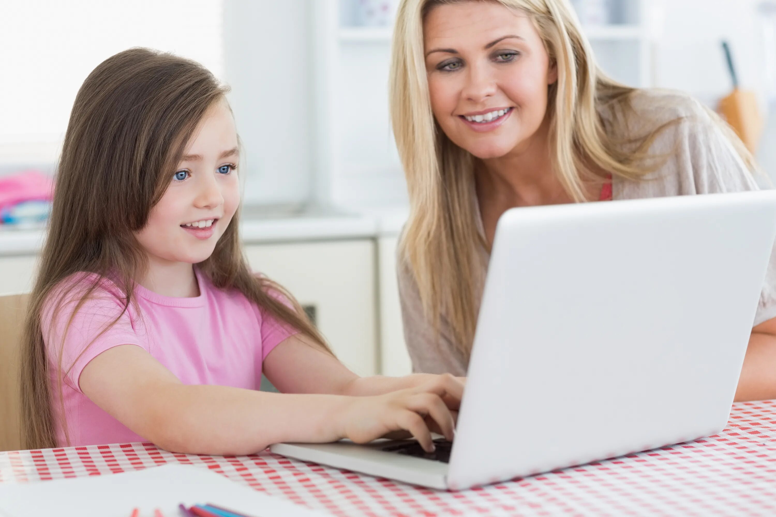 Мама печатает. Маленькая улыбающаяся девочка с мамой у компьютера. Ученик печатает на компьютере. Печатать маму. Яркая картинка девушка с ребёнком возле ноутбука.