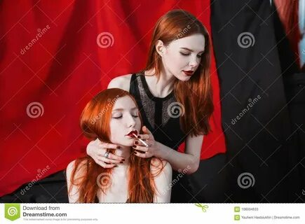 Abrazo pelirrojo y humo de la muchacha dos en fondo negro y rojo Dos mujere...
