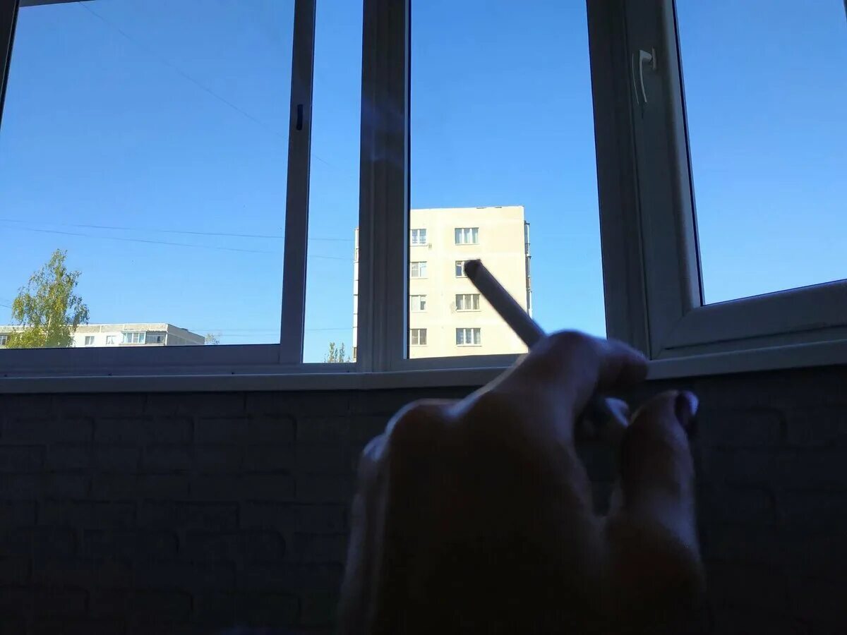 Курит у окна. Курение на балконе. Курящий человек на балконе. Видео курим на балконе. С сигаретой на балконе.