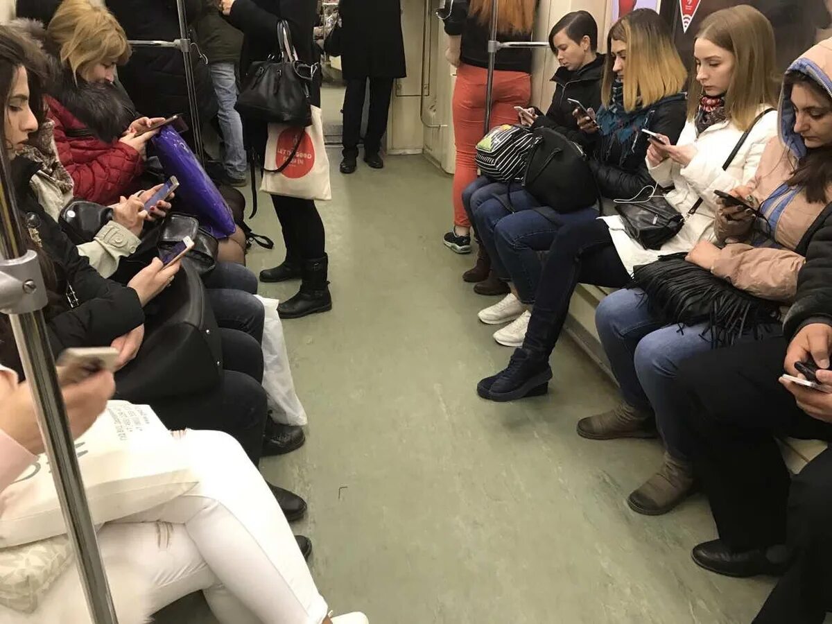 Подросток в московском метро. Люди с телефонами в метро. Люди со смартфонами в метро. Человек сидит в метро. Человек в транспорте и смартфон.