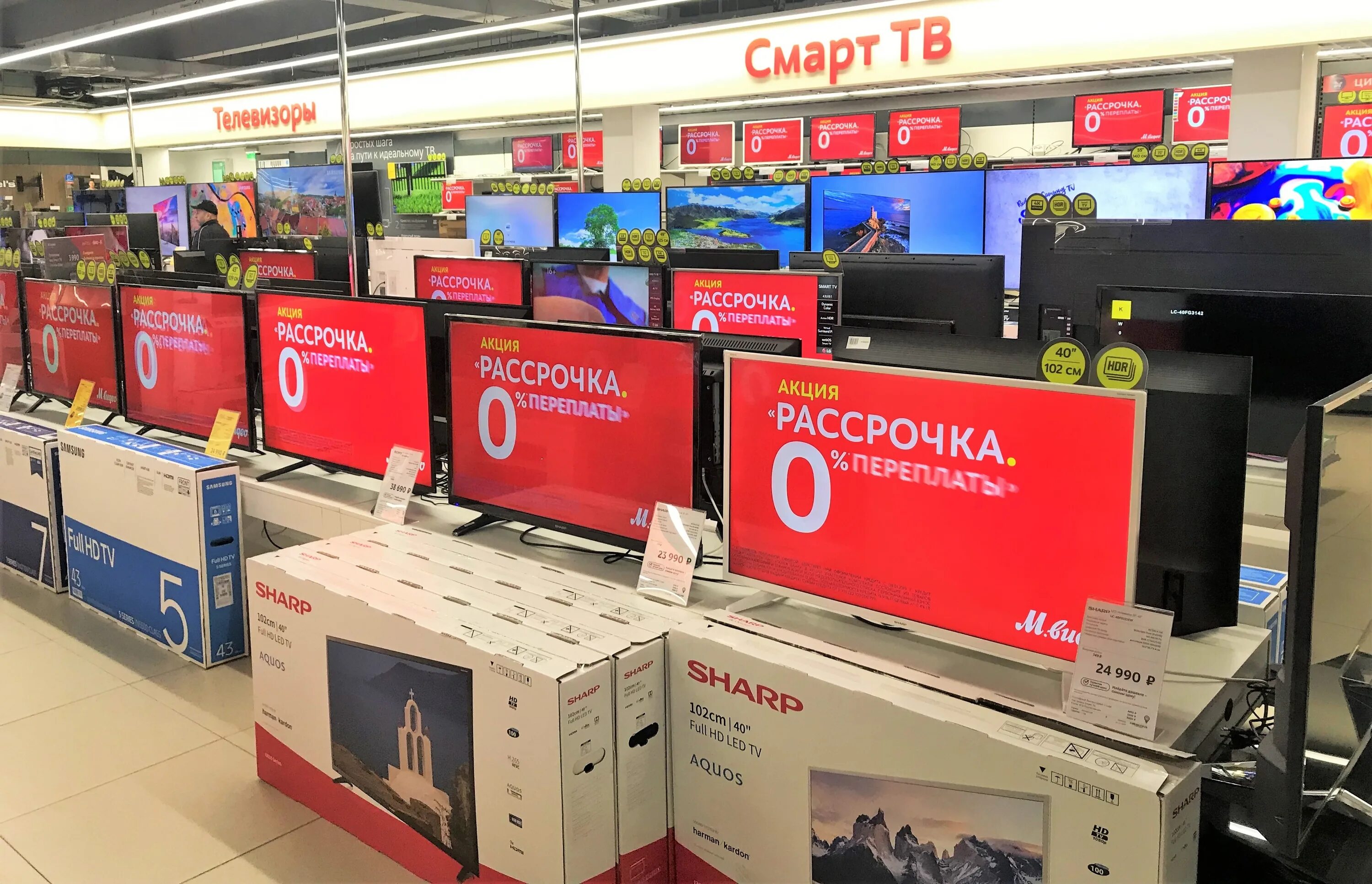Магазины техники телевизоры. Телевизоры в магазине м видео. Упаковка телевизора.