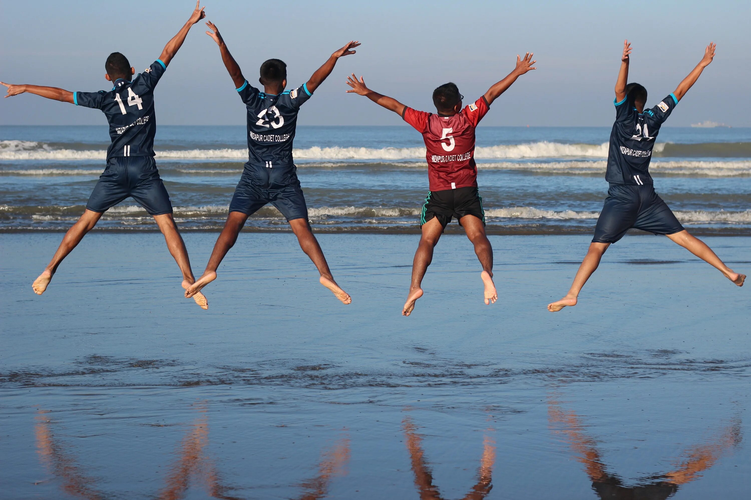 Natural fun. Четыре человека прыгают. Необычные действия людей. Пляж море люди. Фотографии людей в действии.