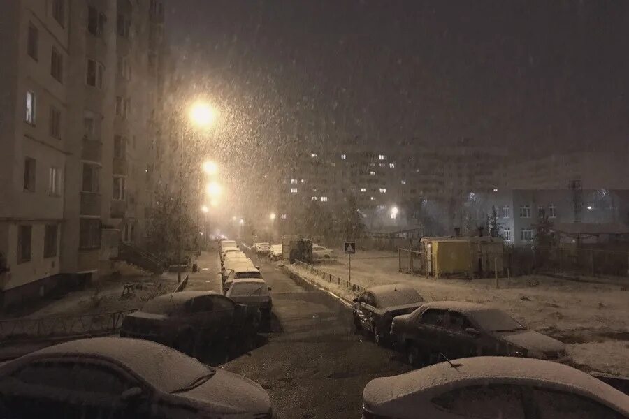 Вечером 1 ночью 0. Вечер города дворы снег. Заснеженный двор вид из окна. Первый снег в городе вечером. Вечерний снегопад в городе.