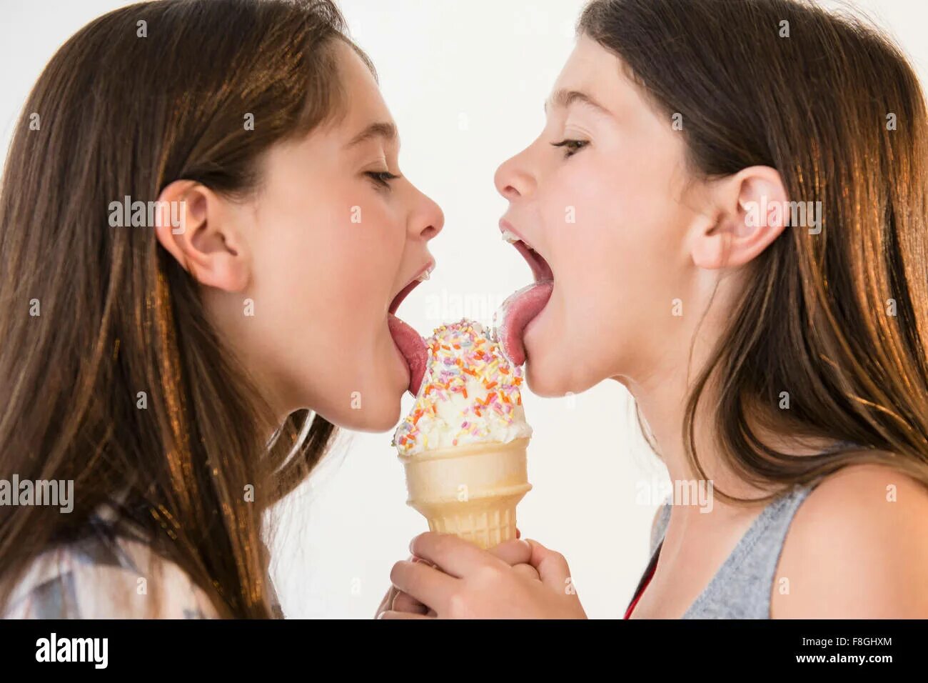 Two girls lick. Девочка облизывает мороженое. Девочка лижет. Две девочки облизывают. Дети лижут мороженое.