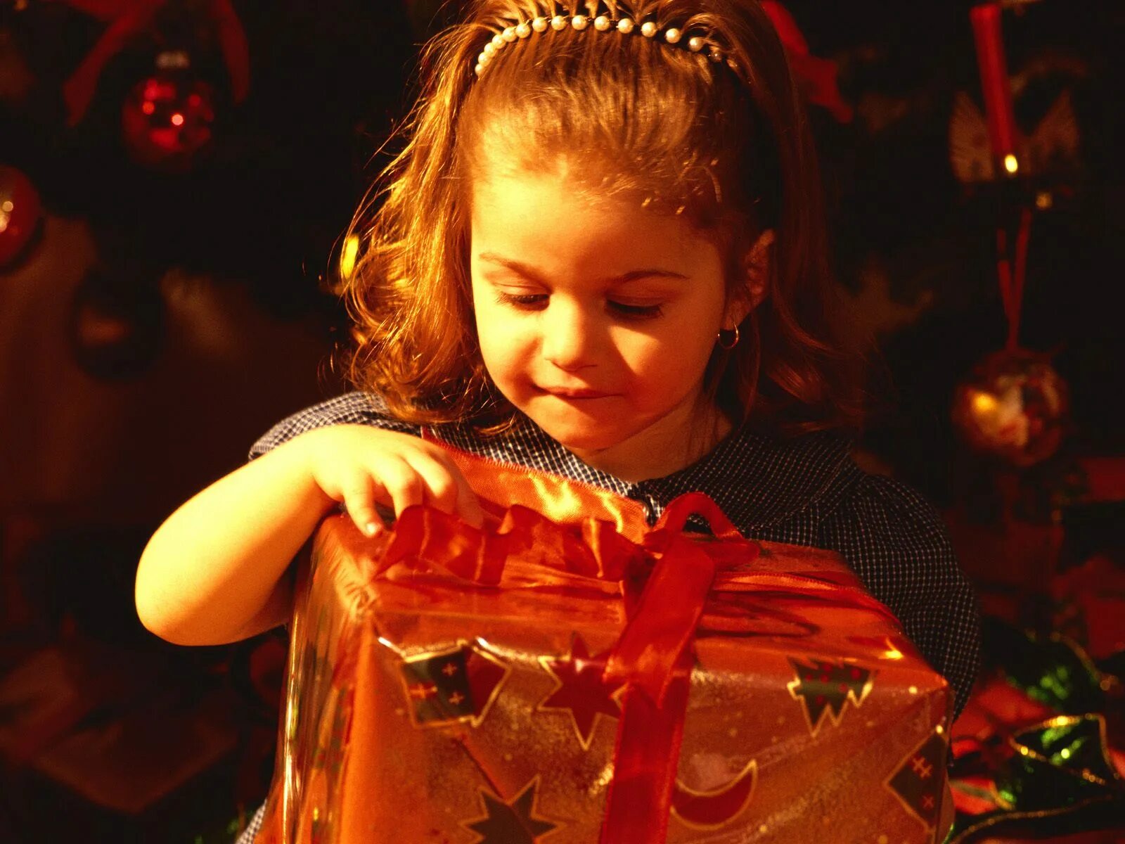 Радуюсь новому году. Новогодние подарки для детей. Подарок для девочки. Маленькая девочка с подарком. Девочка радуется подарку.