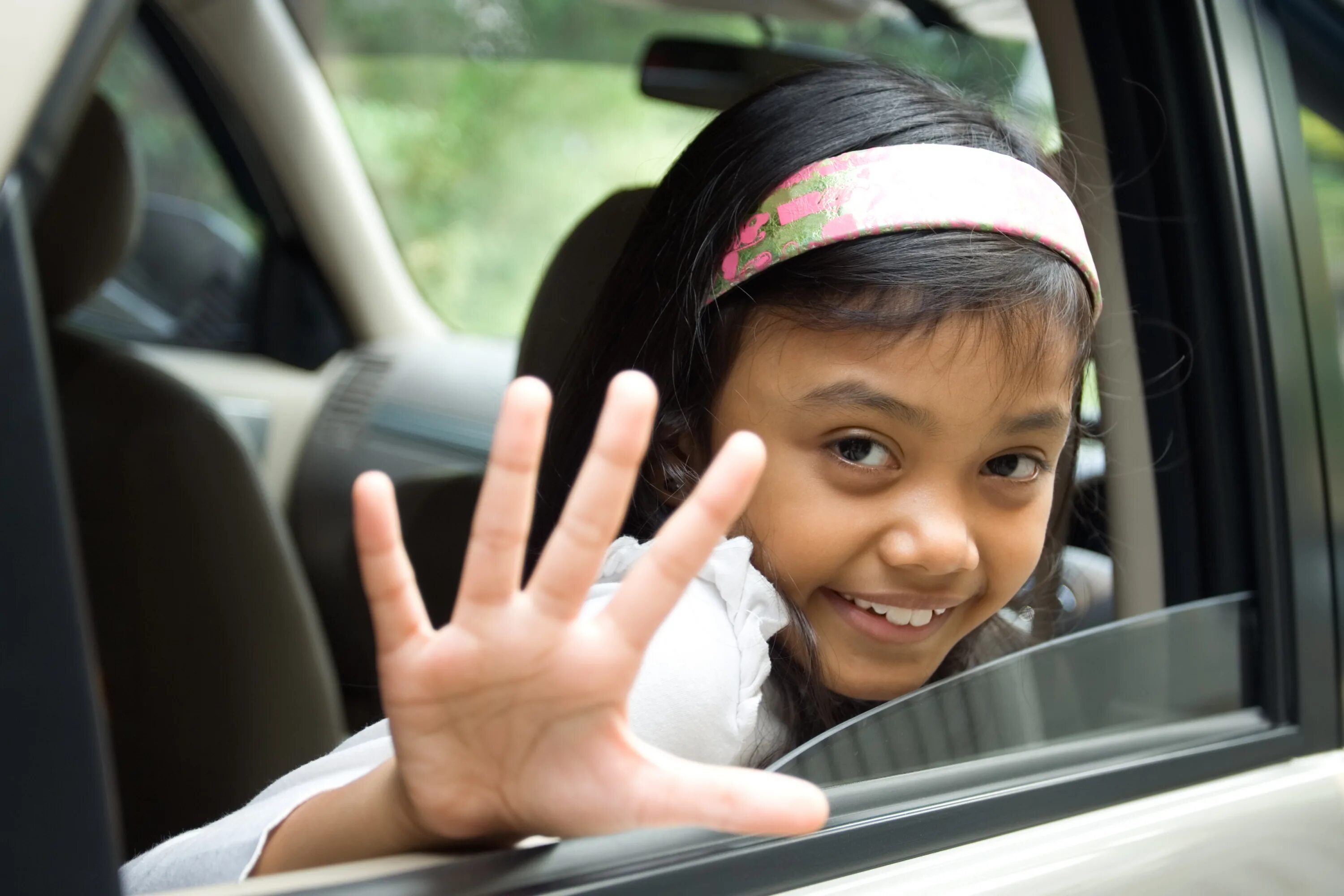 Прощание в авто. Девочка машет рукой из машины. Ребенок из машины машет рукой. Девушка машет рукой. Дети машут на прощание.