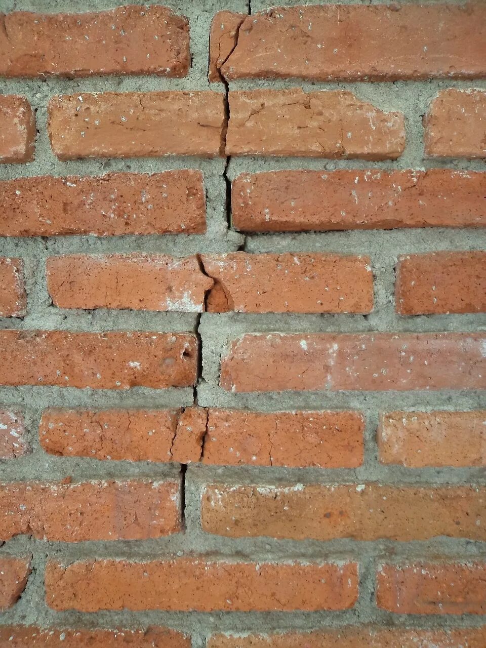 Пошла трещина по стене. Трещина в кирпичной стене. Трещины в кладке кирпича. Вертикальные трещины в кирпичной кладке. Дефекты кирпичных стен.