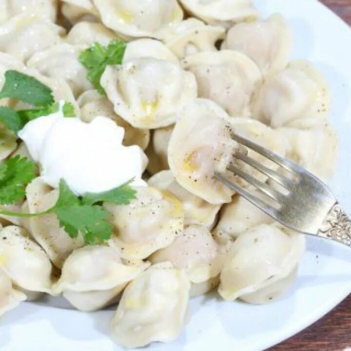Когда можно есть пельмени. Пельмени со сметаной. пельмешки со сметаной. пельмешки в тарелке. тарелка пельменей.