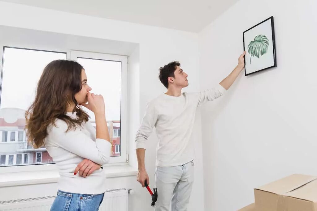 На что вешать картины на стену. Мужчина вешает картину. Муж прибивает картину. Женщина вешает картину на стену рисунок.