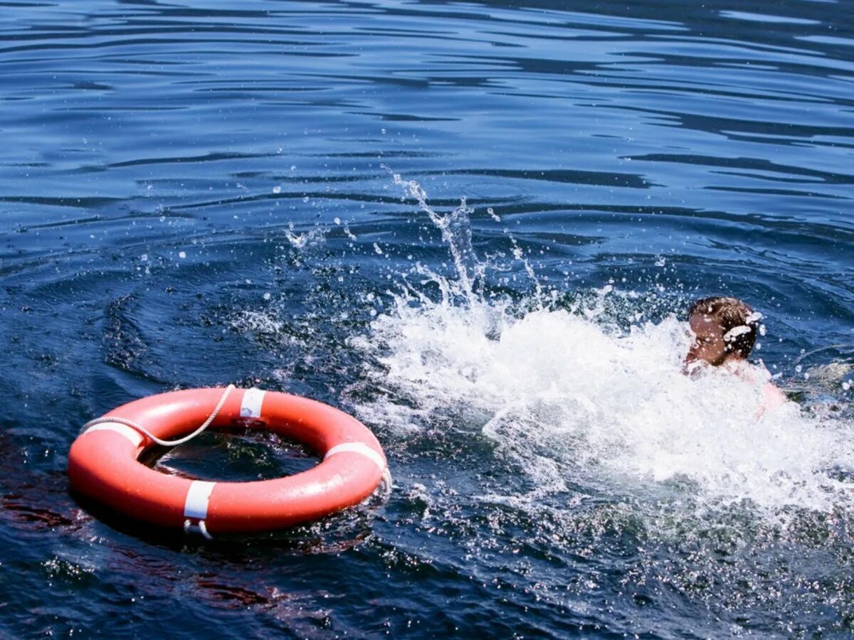 Человек в спасательном круге. Спасательный круг на воде. Человек в спасательном круге в воде. Человек тонет спасательный круг.